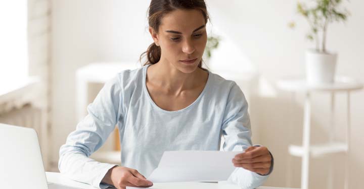 A woman sitting at a table reviewing a character letter for a child custody hearing