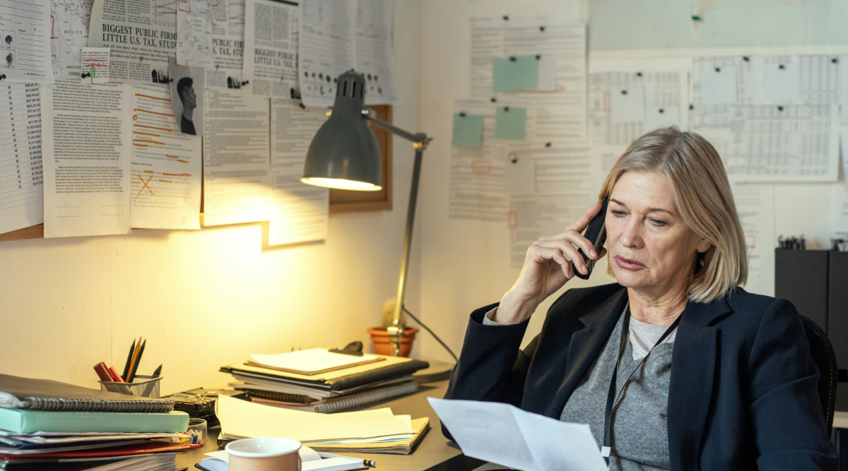 A lawyer sits at her desk and talks on the phone while reviewing documents for a wrongful death lawsuit.