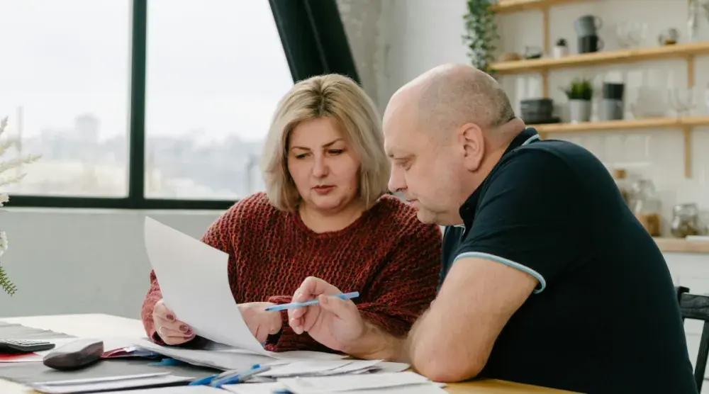 An attorney with blonde hair and a red sweater guides a man through the LLC process and the costs involved.