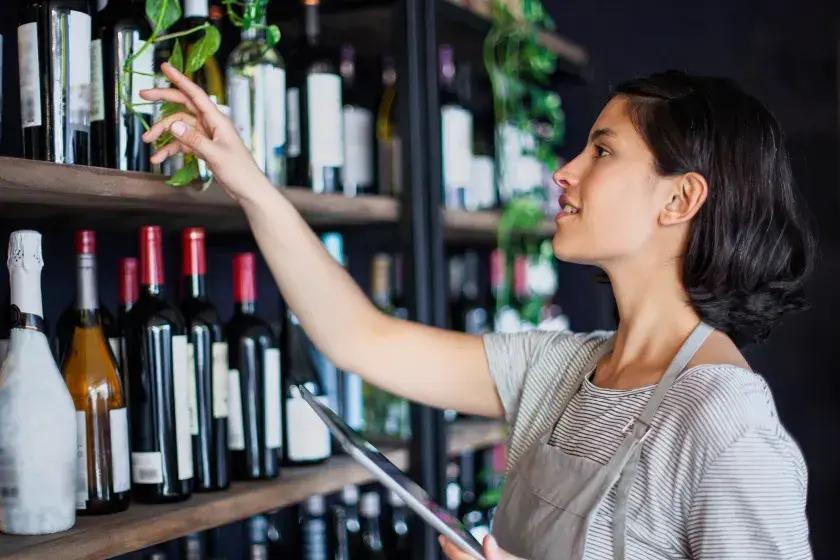 The owner of a wine shop checks inventory. A beneficial owner is one who really holds the power and financial interest in a business, and a beneficial ownership report must be filed with the U.S. government..