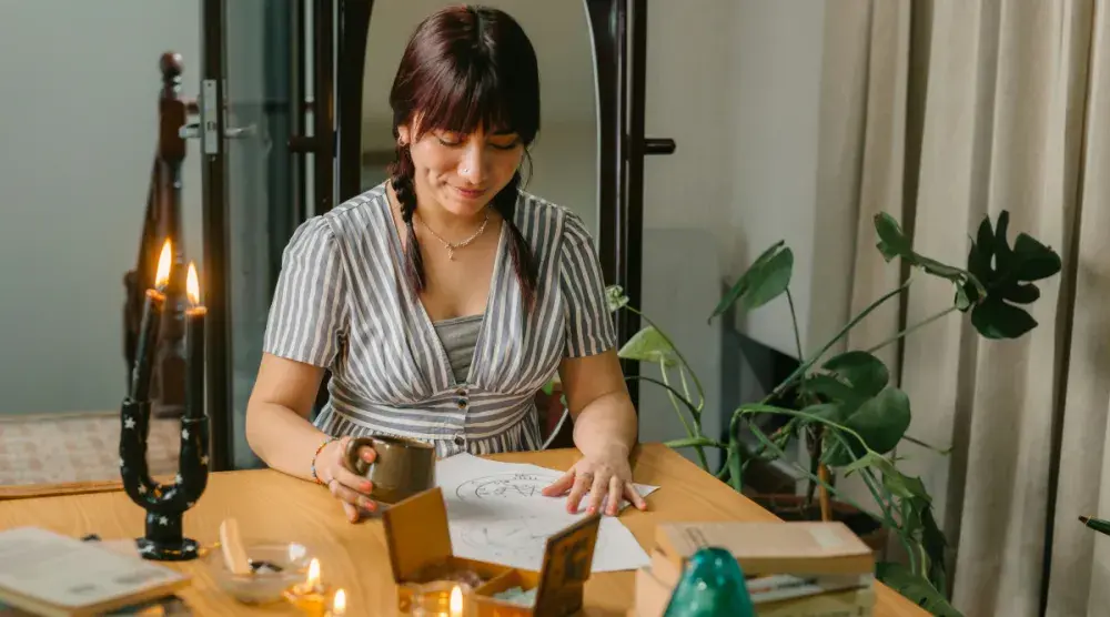 A New Hampshire LLC owner sits in her studio and reviews her artwork.