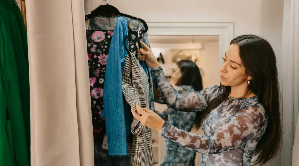 A woman sorts through items in her closet while deciding what to wear to court.