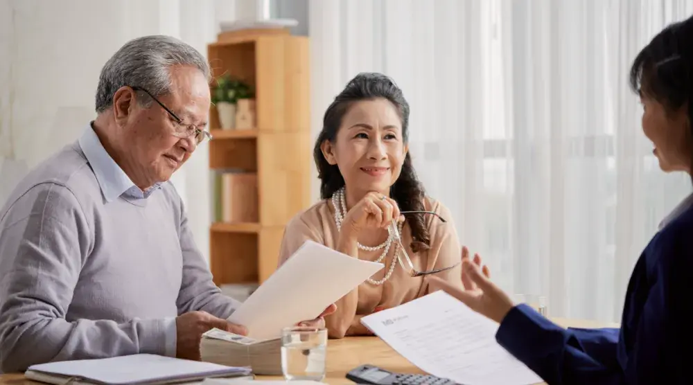 A couple reads through their living trust while their lawyer explains it.