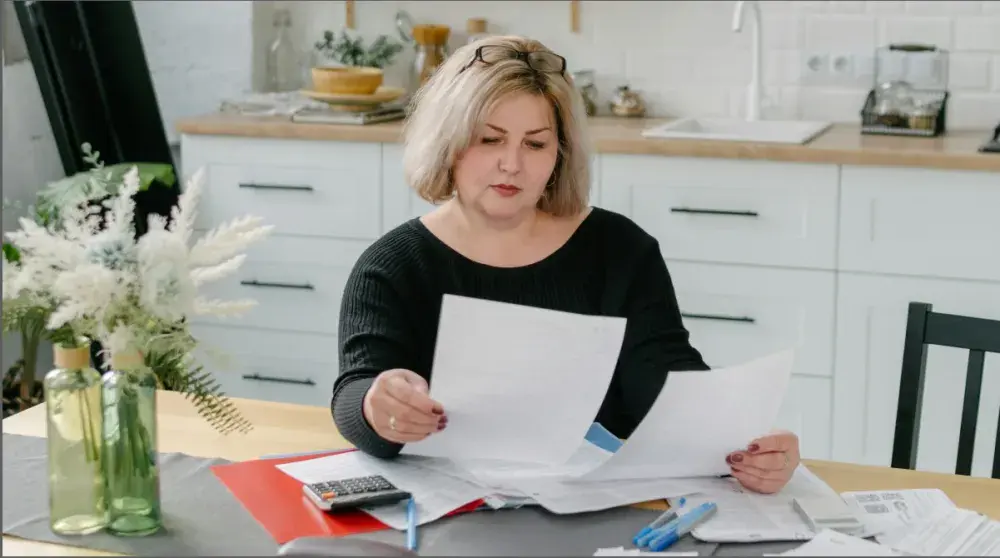 A family attorney sits at her desk and examines divorce papers for a client. The duration of alimony payments depends on the negotiated terms and the specific type of alimony.