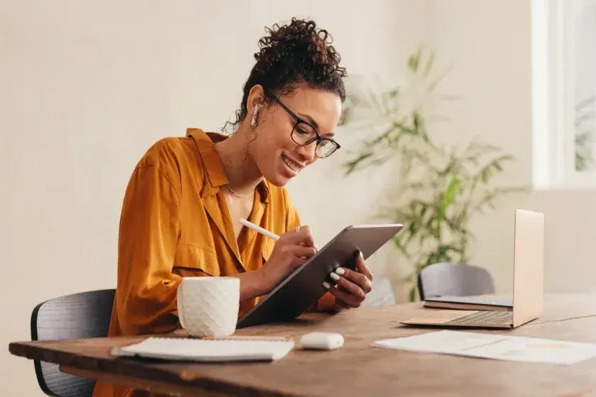 A woman sits at a table and calculates her capital gains tax.