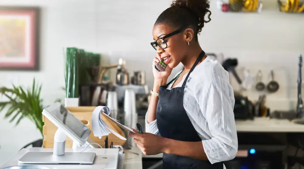 A small business owner talks on her phone to a real estate attorney about a commercial lease. Within the two categories of commercial leases—gross lease and net lease—there are plenty of options for negotiation.