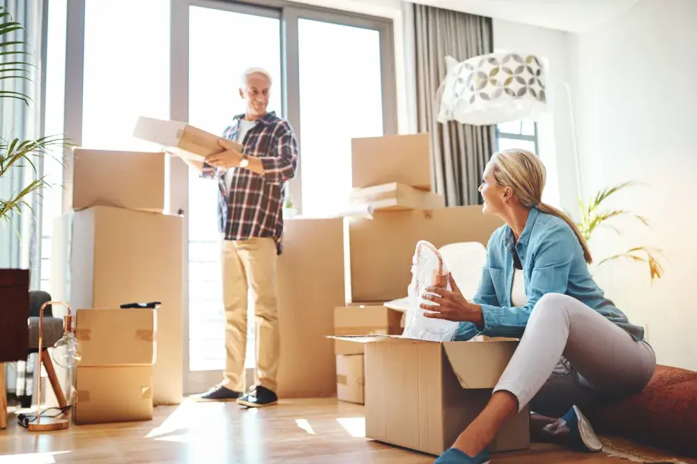 A man and woman pack up the belongings of a deceased loved one to sell at an estate sale. 