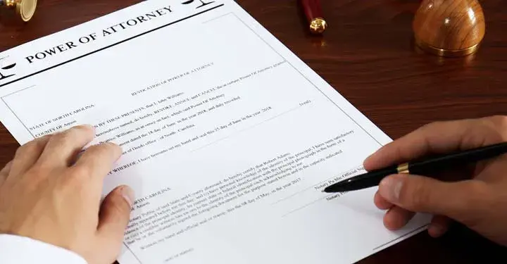 Man signing power of attorney document with ballpoint pen