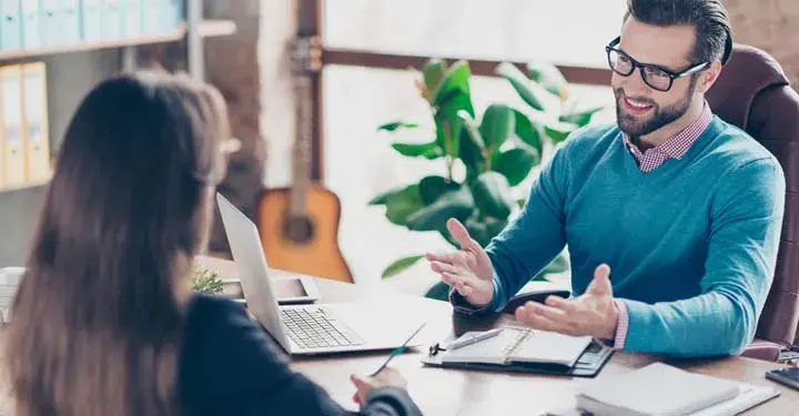 Man sitting in office speaking with an employee