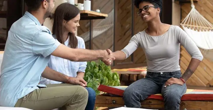 Woman shaking a couple's hands