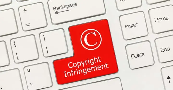 Red key on computer keyboard which says "copyright infringement"