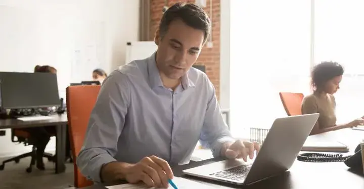 man going over paperwork at his desk