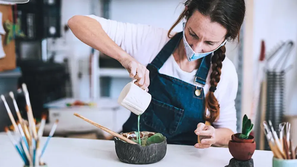 A potter pours a glaze in her workshop after filing her BOIR paperwork. FinCEN can hold senior officers personally accountable for a company's failure to file required reports.