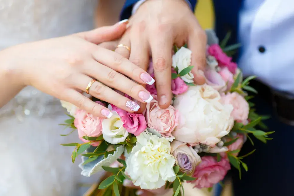 A woman rests her hand on top of a bouquet of flowers as her fiance. what every couple in New York should know about the world of prenuptial agreements.