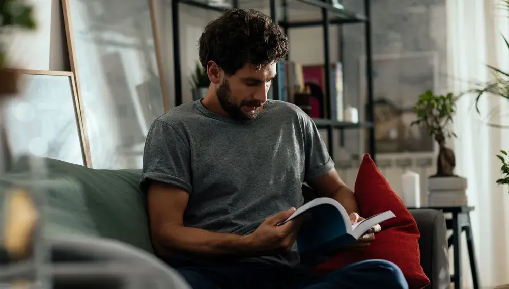 man sitting in his living room reading a book