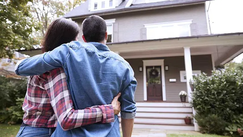 couple hugging looking at home 