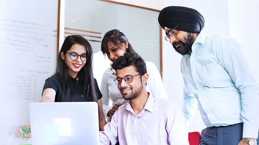 coworkers looking at a laptop sharing 