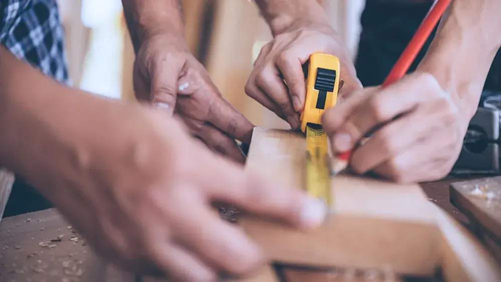 Two people use a measuring tape on a piece of wood for their carpentry business. Florida does not require your LLC to file an operating agreement, but it is an essential business component. 