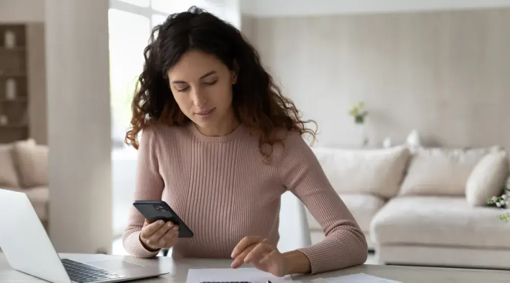 Woman seated at desk calculates cost of divorce