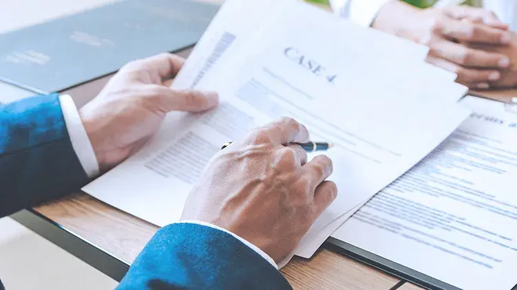 man-suit-reviews-case-paperwork-with-client