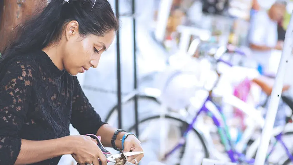 A woman cuts a piece of fabric in her shop. Retirement accounts, health and medical savings accounts, and active financial accounts cannot be included in a trust.