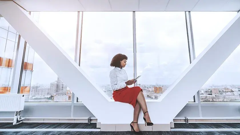 A woman seated in an office lobby puts finishing touches on her operating agreement for her new LLC.