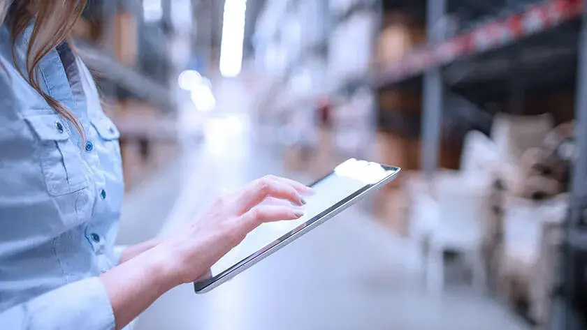 woman looking at her ipad in a warehouse 