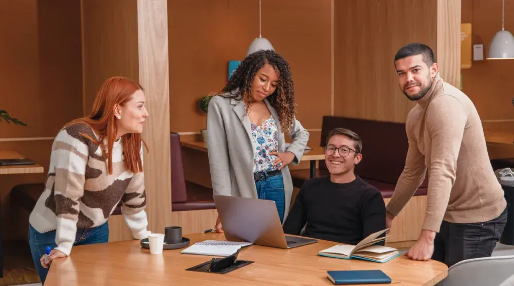 Business leaders gathered around a table discussing how to prevent a hostile work environment