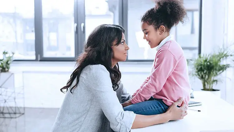 Mother having serious talk with young daughter