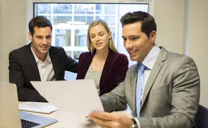 Smiling coworkers reviewing paperwork in an office