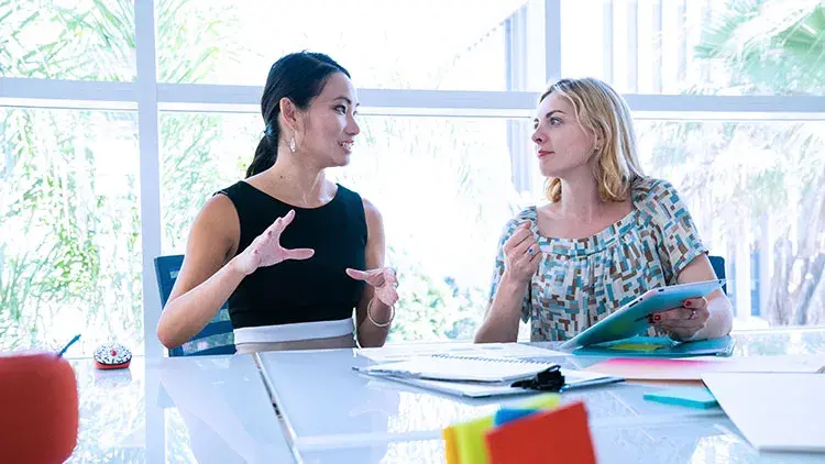 Two woman talking business plans