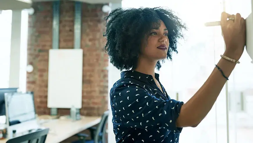 hero-trademark-you-startup woman writing on board in black and white shirt 