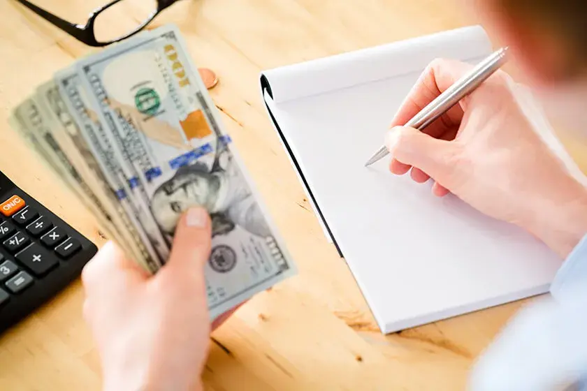 man with calculator going over paperwork 