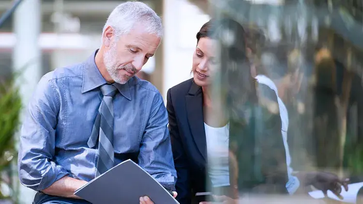 man going over doc with woman outside