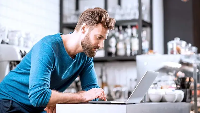 Man on laptop in coffeeshop