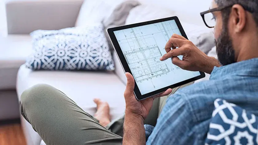 man-planning-architecture-on-tablet sitting on the sofa