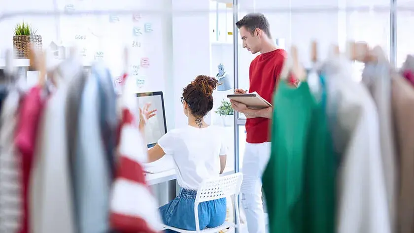 man and woman discuss business looking at computer 