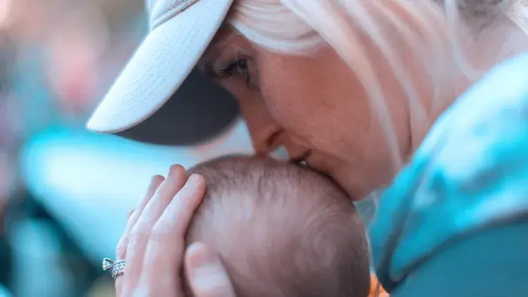 Mother kissing baby head