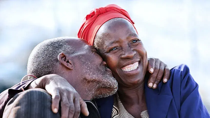 seniors-hugging-smiling-outside