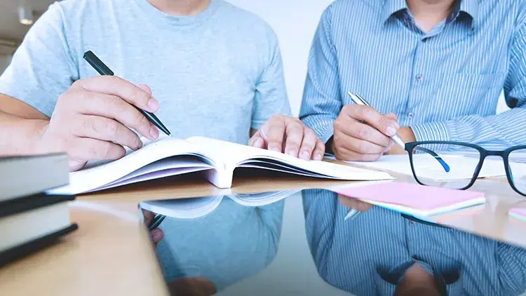 Two men side by side going through documents