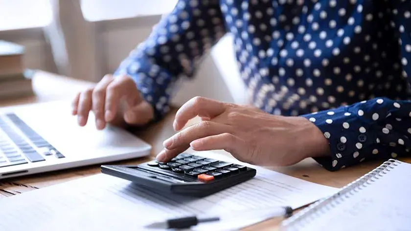 woman using calculator at desk