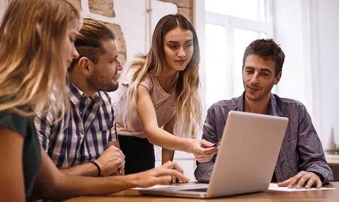 LLC owners at laptop discussing hiring their first employees 