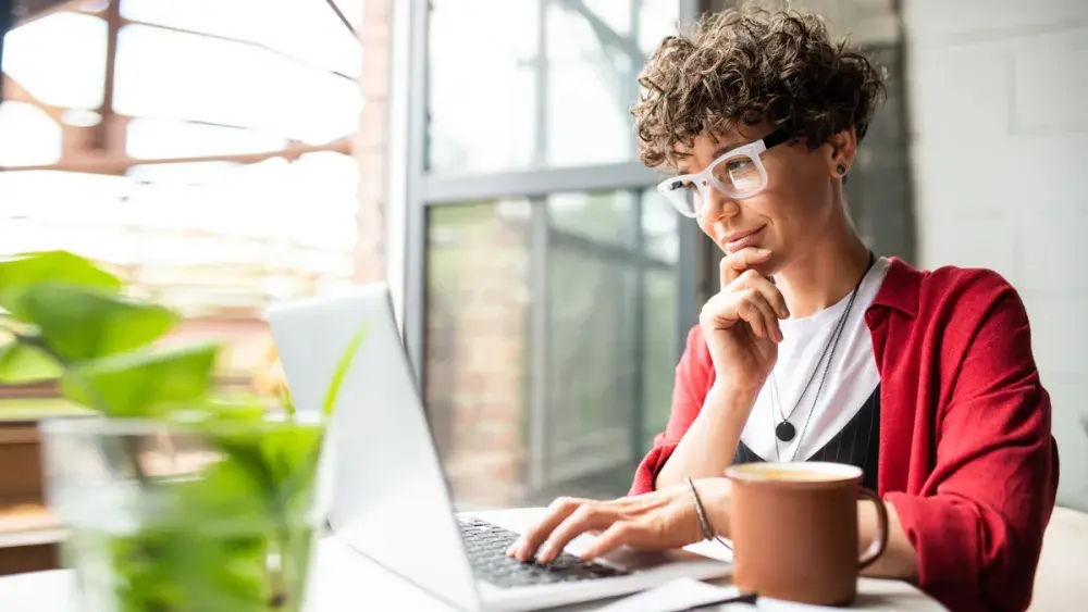 A woman looks at a laptop while determining whether her credit card interest is tax deductible.