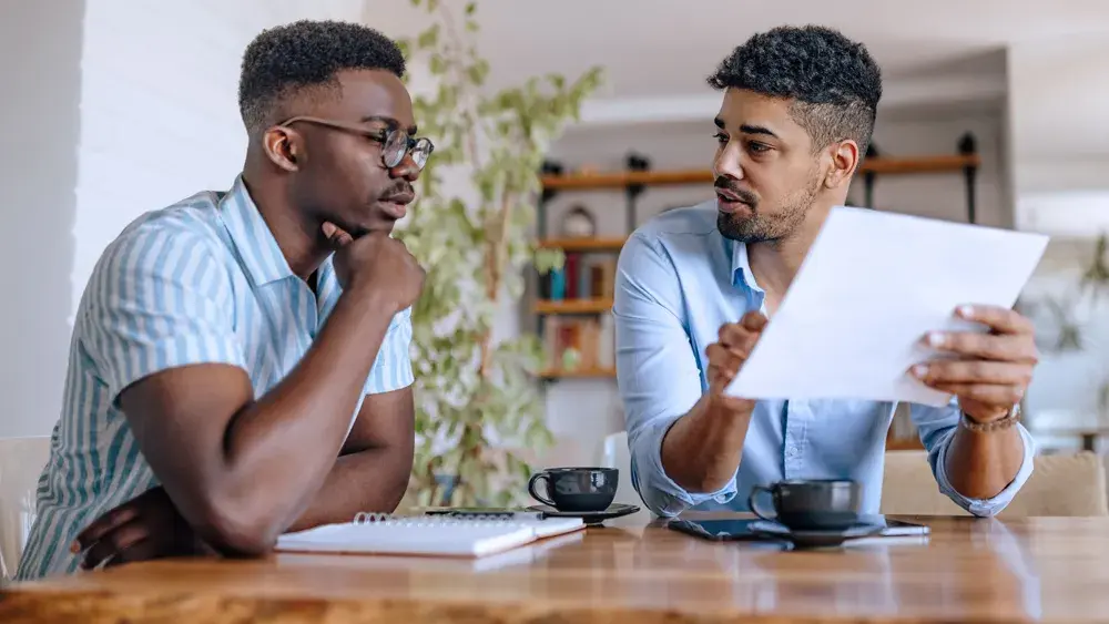 A married couple sits at their dining room table to discuss their assets and other interests they would like to include in their living trust.