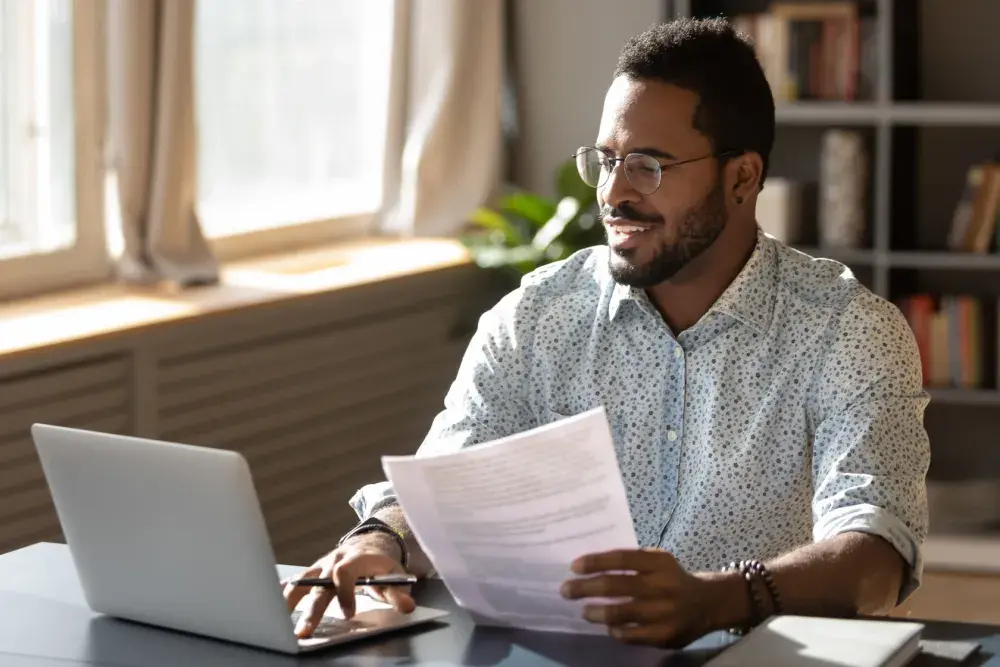 A man seated at a desk looks online to learn how to get an EIN number.