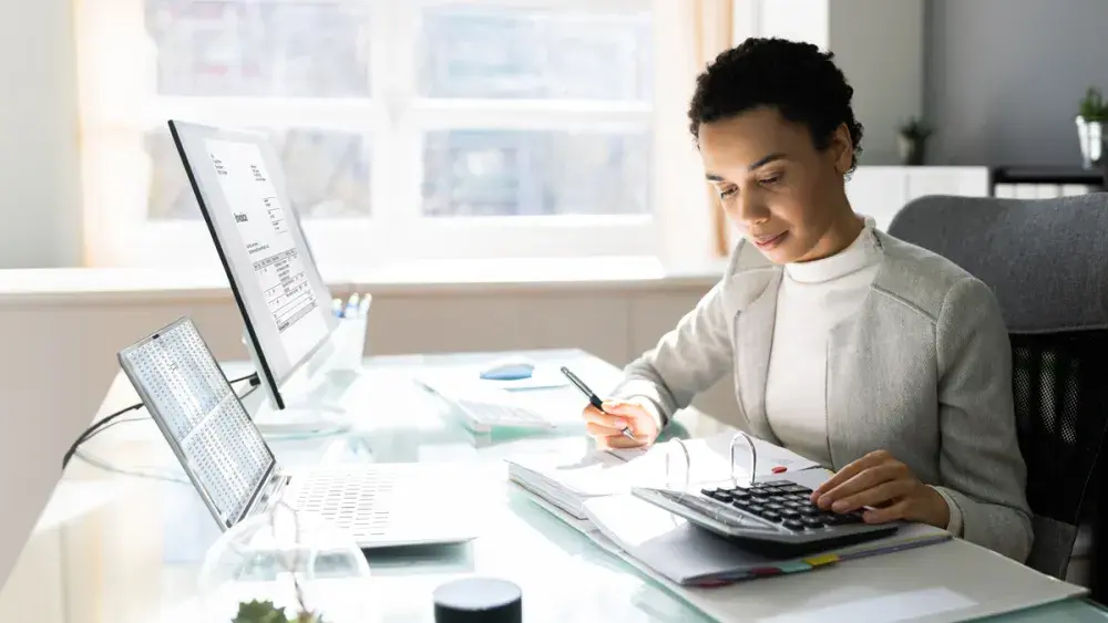 A woman uses a calculator to determine how incentive stock options are taxed.