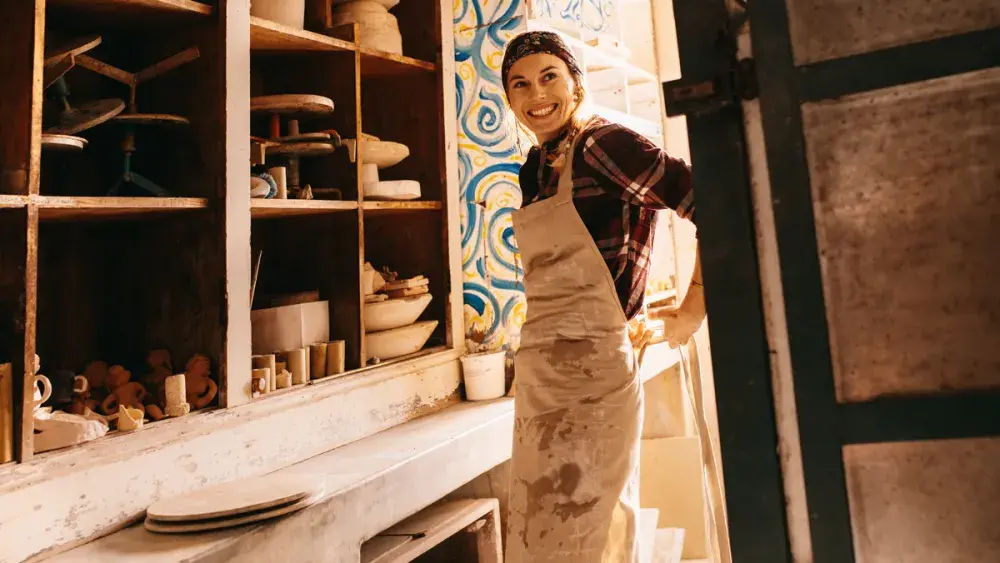 A pottery artist puts on an apron at her business. Self-employed people have several options when it comes to retirement.