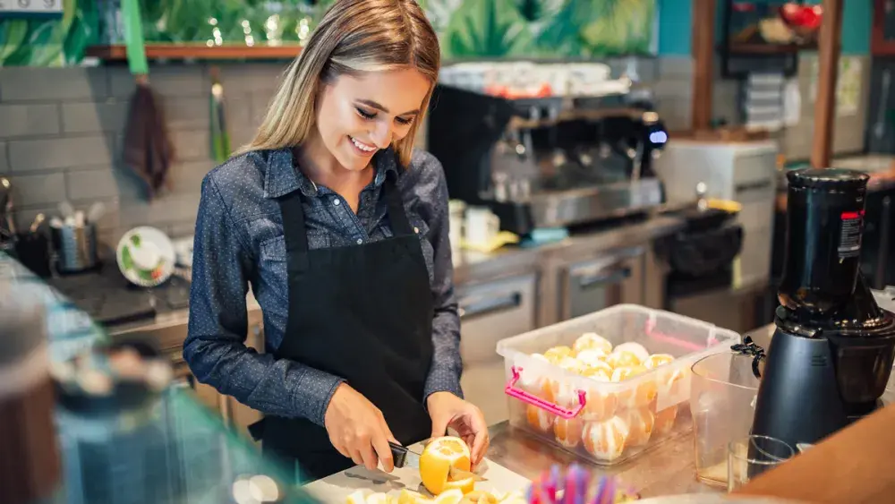 A woman slices lemons while considering tax planning for her business.