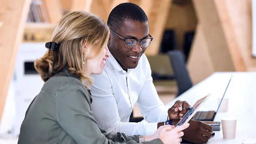 business-meeting-woman-and-man-looking-at-device-laptop