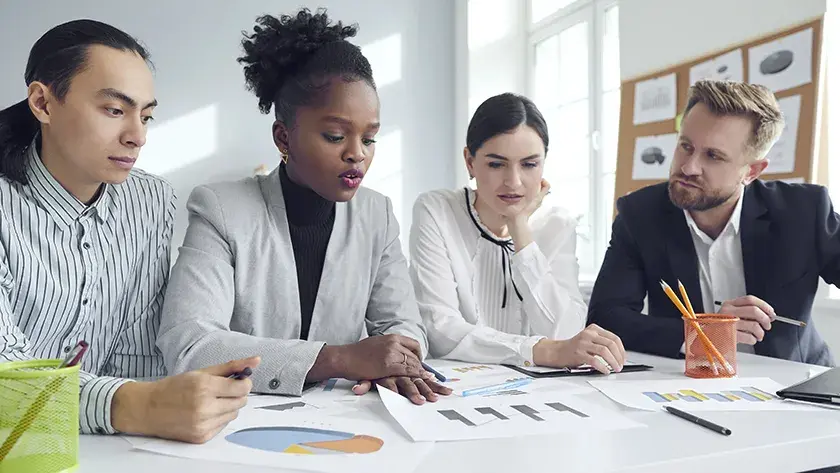 coworkers collaborating over paperwork in a conference room